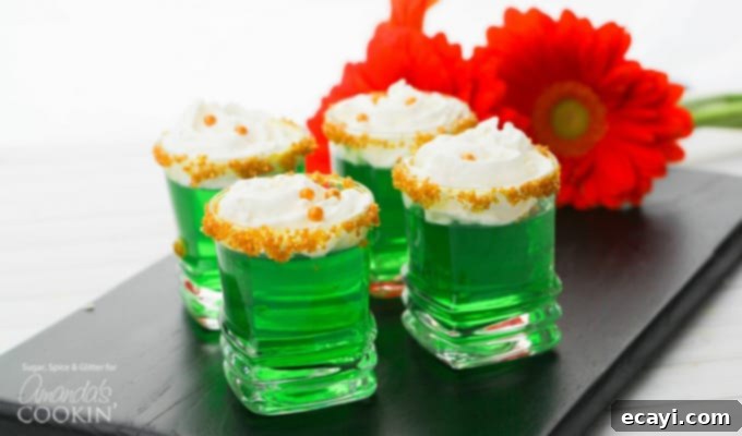 These Green Jello Shots with gold sugar rims and a dollop of whipped cream are perfect for St. Patrick's Day but are good for all summer long, too! #stpatricksday #jelloshots #jello #cocktails #summer #vodka #lime Green Jello Shots for St. Patrick's Day