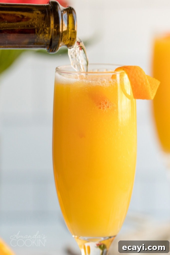 Master the art of mimosa making for your next brunch. This easy recipe combines champagne and orange juice, garnished with an elegant orange peel twist, making it the perfect low-fuss brunch cocktail. pouring champagne into an orange juice-filled flute