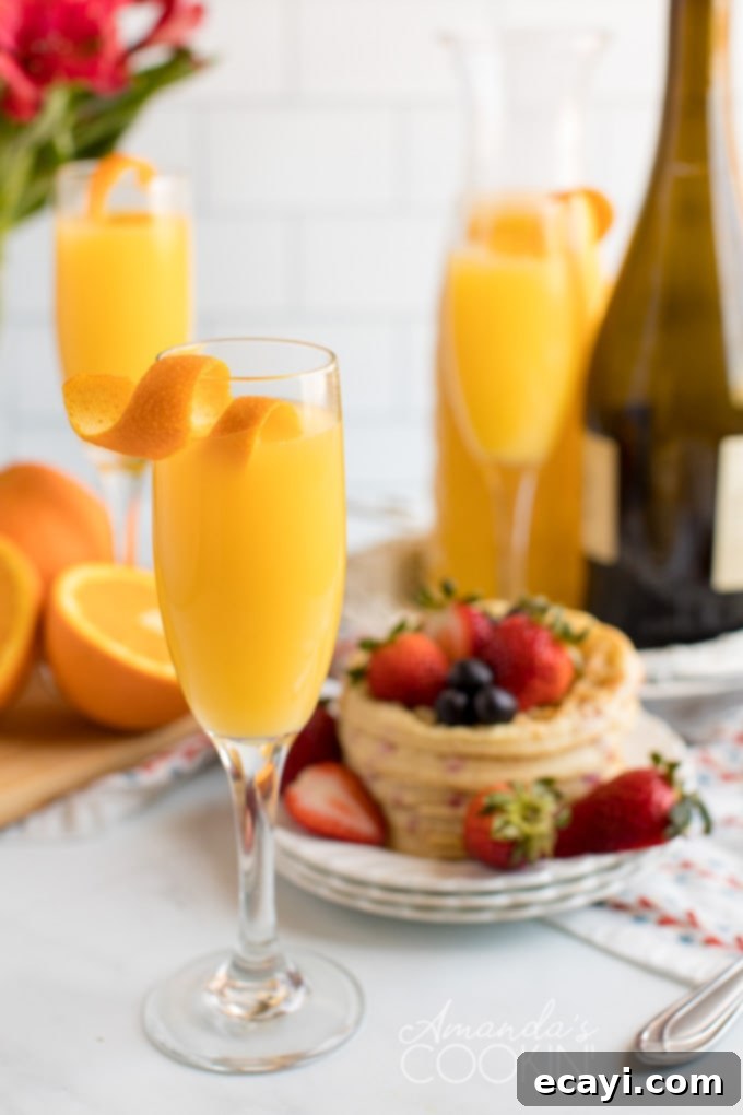 Mimosas, made from orange juice and champagne, are an easy to make and replenish, making them the perfect low-fuss brunch cocktail for all occasions. Enjoy with your favorite brunch foods. three glasses of mimosas with waffles in the background, ready for brunch