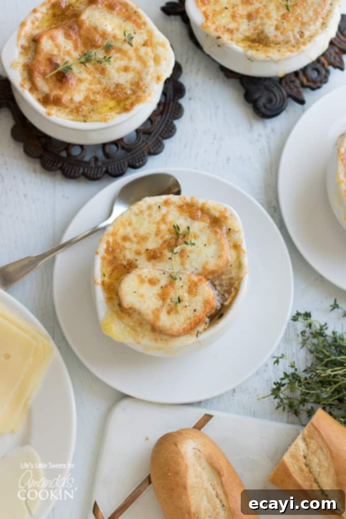 A comforting bowl of French Onion Soup, topped with perfectly broiled cheesy bread, captured from above. Overhead shot of French Onion Soup in a bowl with a spoon, highlighting the rich texture and melted cheese