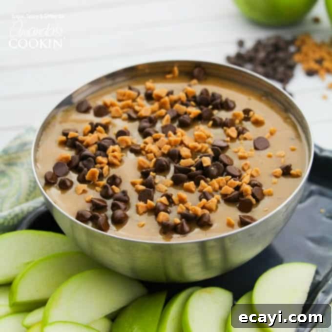 Luscious Caramel Apple Treat 4 Elegant silver bowl brimming with creamy homemade caramel apple dip, garnished with chocolate chips and toffee bits for a beautiful presentation.