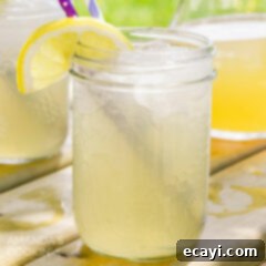 Lynchburg Lemonade 8 Mason jar glass of Lynchburg lemonade with a straw and lemon wedge garnish.
