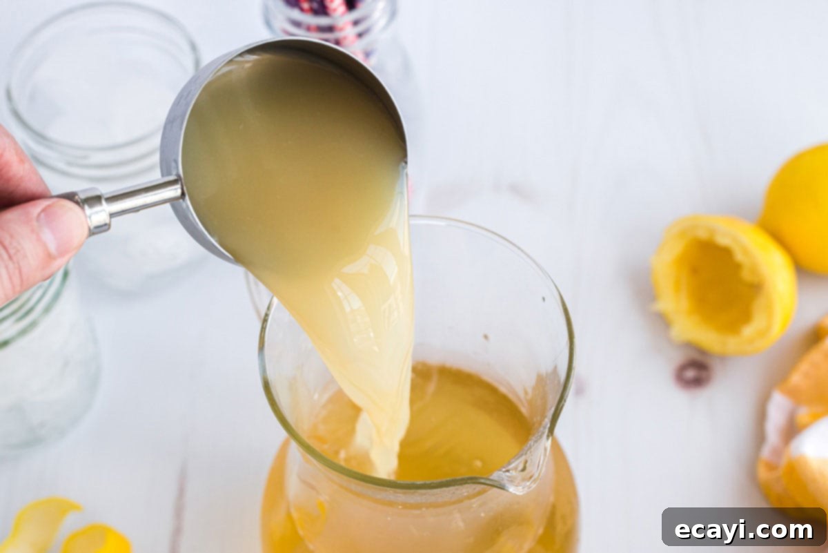 Lynchburg Lemonade 4 Pouring freshly squeezed lemon juice into a large glass pitcher