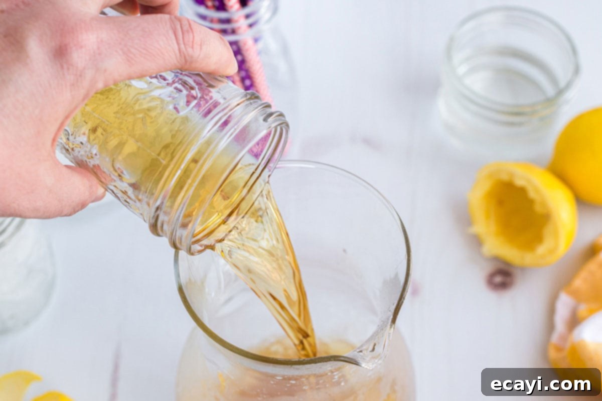 Lynchburg Lemonade 5 Adding Jack Daniel's whiskey to the pitcher with lemon juice