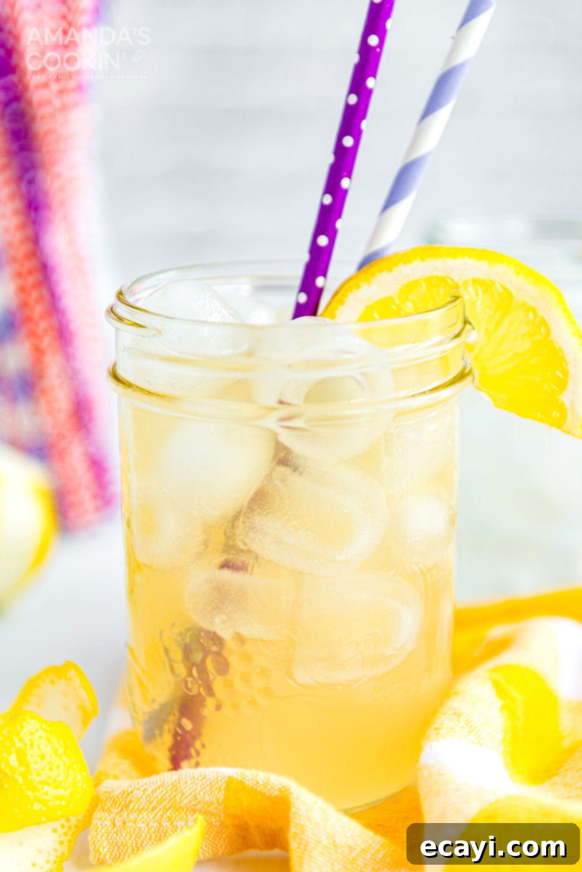 Leave the lemonade for the kids and mix up this Lynchburg Lemonade for your next BBQ - a Jack Daniels-spiked lemon cocktail that is surprisingly smooth. A mason jar glass of Lynchburg lemonade, garnished with a lemon wedge and a colorful straw