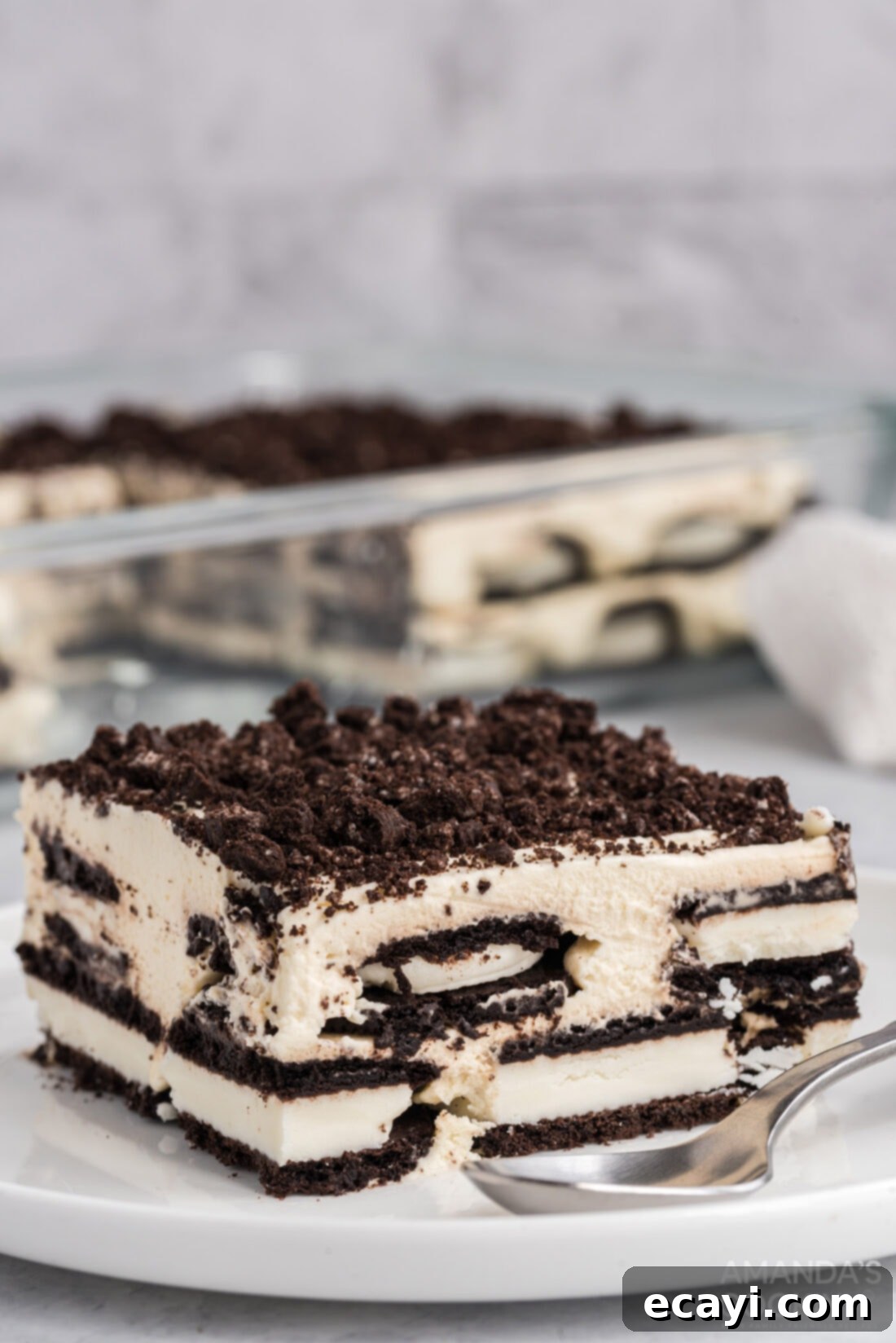 No-Bake Oreo Delight 2 A perfectly sliced piece of Oreo Icebox Cake, revealing layers of dark Oreo cookies and creamy white whipped cream.
