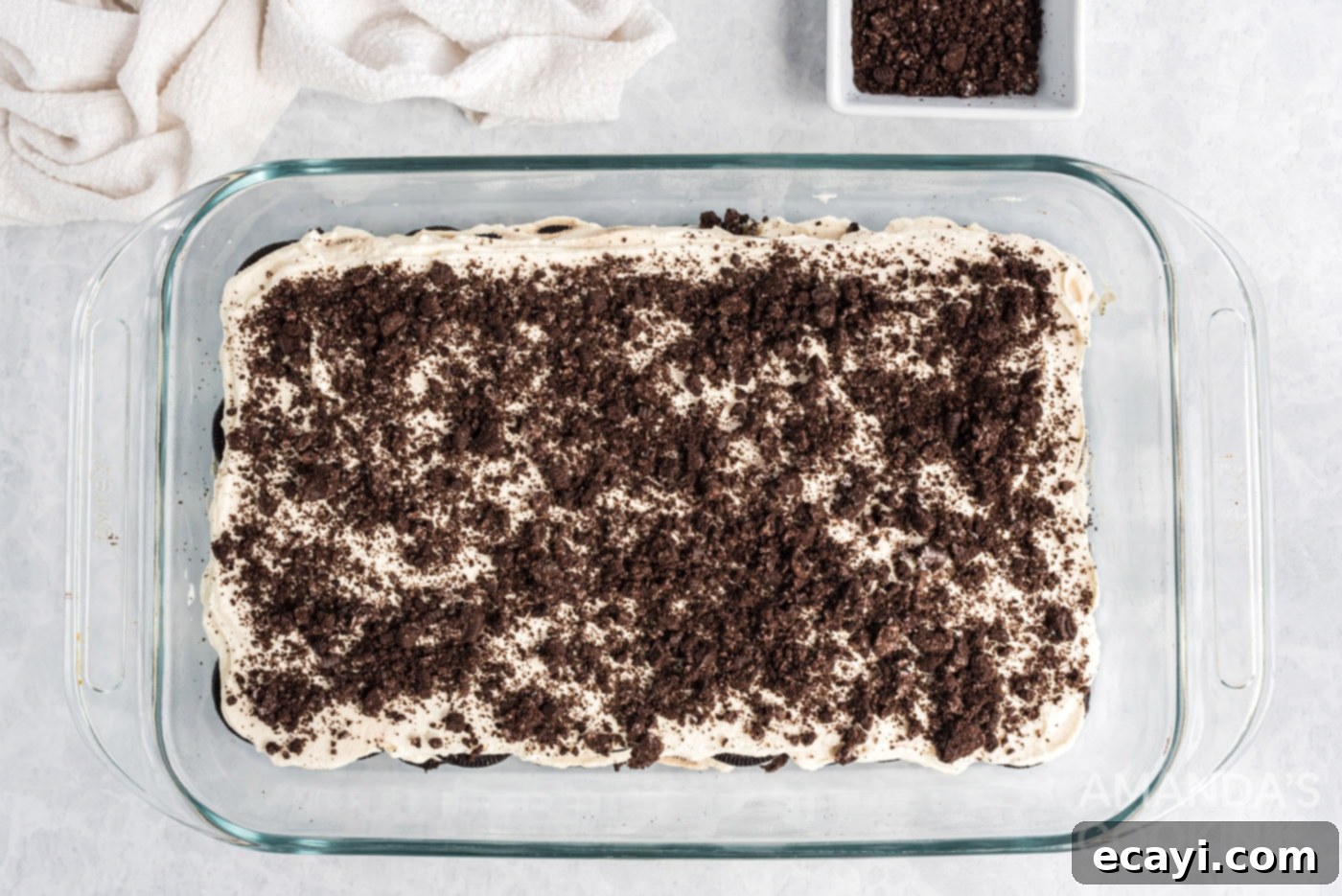 No-Bake Oreo Delight 8 Crushed Oreo cookies sprinkled generously over the top of a finished Oreo Icebox Cake, ready for serving.