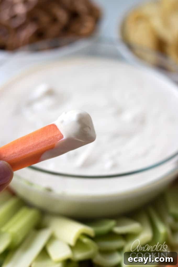 Luscious Onion Swirl 5 A beautifully presented bowl of creamy onion dip surrounded by an assortment of fresh, colorful vegetables like carrots, celery, and broccoli, perfect for healthy dipping.