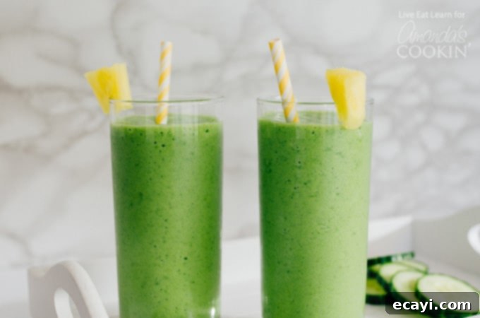 This Cucumber Tropical Smoothie packs in fruits and leafy green veggies, getting you fueled for your day (without the taste of a typical green smoothie). #tropical #smoothierecipes #tropicalsmoothie #cucumber #healthysmoothie #greensmoothie #breakfast #breakfastsmoothie Cucumber tropical smoothies with pineapple wedge