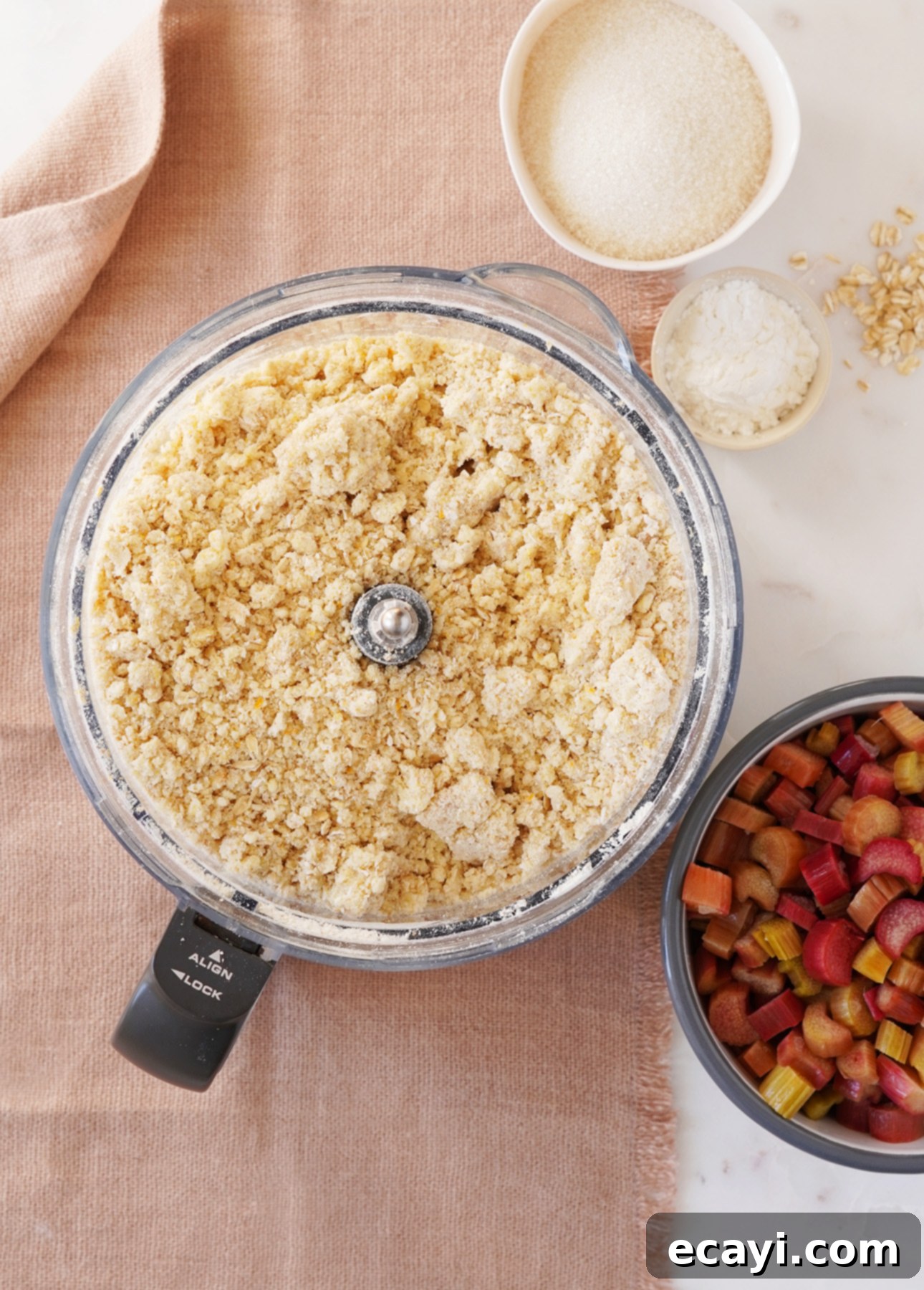Sunshine Rhubarb Orange Crumble Bars 7 Rhubarb crumb mixture in a food processor bowl, with a separate bowl of chopped rhubarb beside it, ready for assembly. // FoodNouveau.com