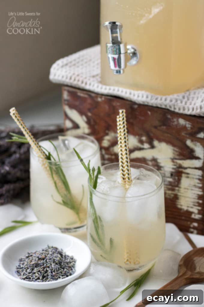 This Lavender Lemonade is made with freshly squeezed lemon juice then sweetened with a lavender-infused simple syrup and garnished with dried lavender! drink in wine glass with lavender flowers