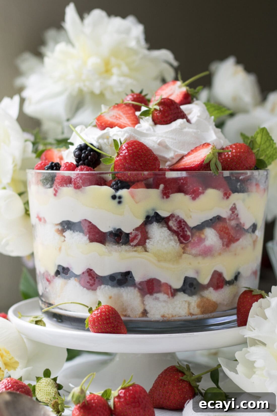 Mixed Berry Trifle with layers of angel food cake, vanilla-lemon cream cheese, pudding, and berries. Close up photo of a Mixed Berry Trifle showing distinct layers of cake, cream, pudding, and fresh berries.