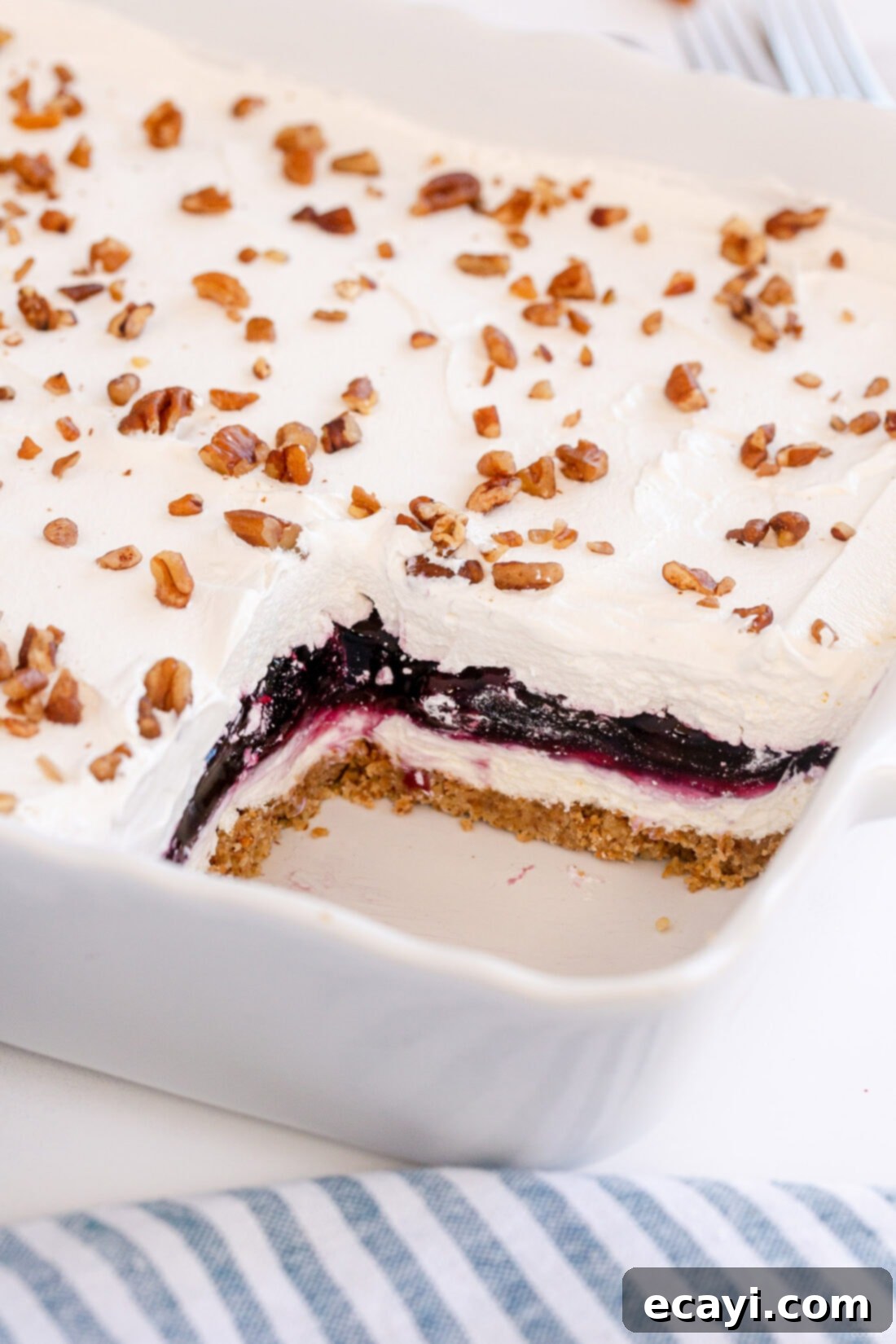 Blueberry Bliss 3 A baking pan filled with freshly made blueberry lush, with one perfect slice carefully removed, revealing all the delicious layers.