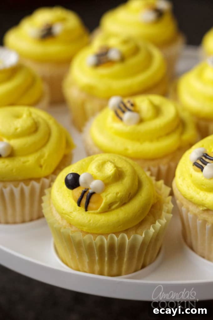 Sweet Honeybee Crowns 2 Close-up of charming yellow frosted cupcakes adorned with homemade bee toppers