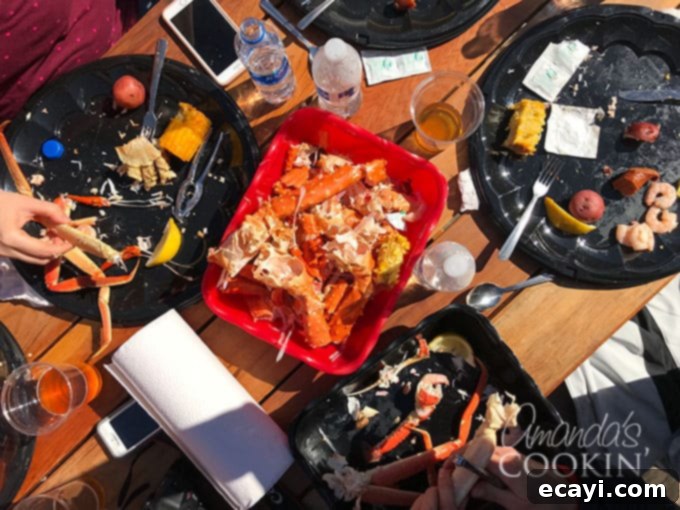 Icy Strait Point Majestic Whale Encounters 7 A mouth-watering spread of fresh Alaskan seafood on a rustic table, featuring cracked King crab legs, corn on the cob, and boiled potatoes.