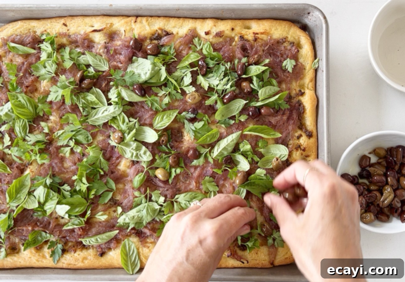 Golden Perfection Pissaladière A Provençal Onion and Anchovy Flatbread 26 Garnishing Provençal flatbread with Niçoise olives and fresh herbs // FoodNouveau.com