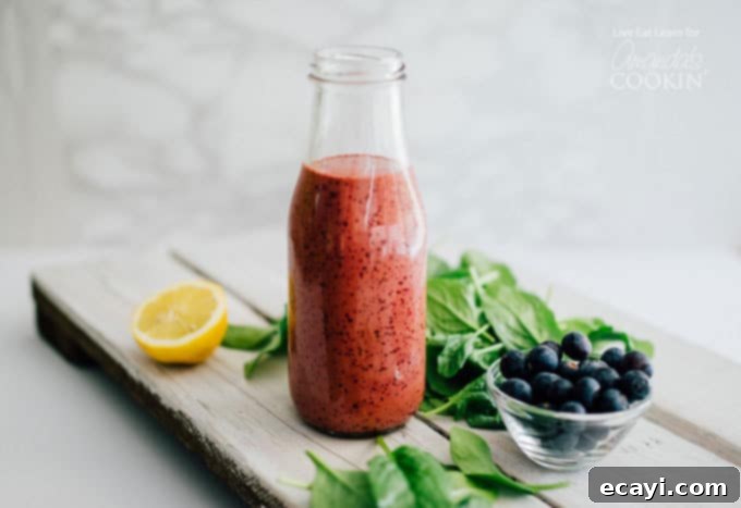 Discover the magic of blending this blueberry vinaigrette for a creamy, velvety dressing that stays emulsified and delicious, enhancing any dish. A charming glass bottle filled with rich, purple homemade blueberry vinaigrette dressing, showcasing its vibrant color and smooth texture, ready to use on any salad.