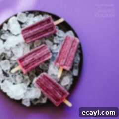 Velvet Blueberry Cheesecake Pops 2 overhead shot of blueberry popsicles on a plate of ice