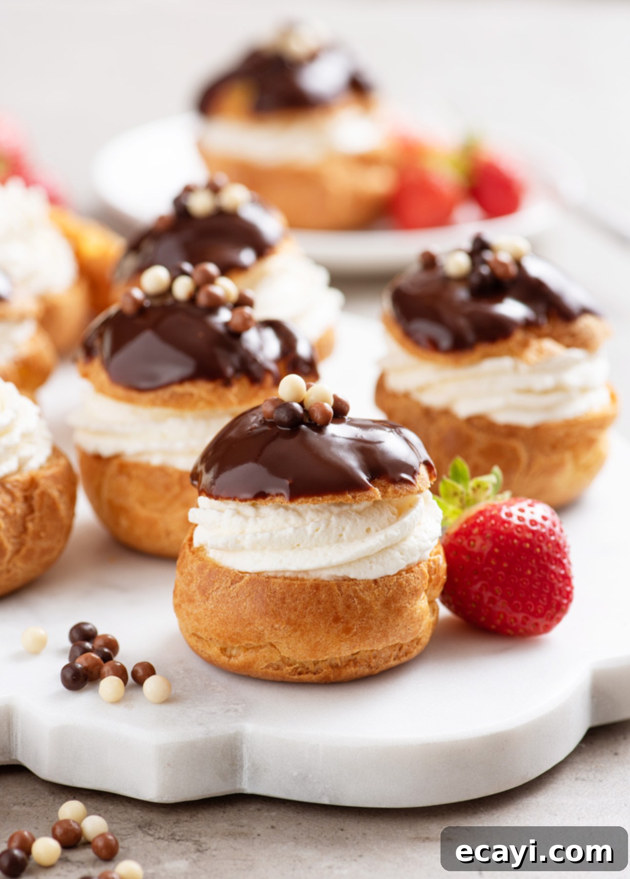 Bake Irresistible Cream Puffs 3 Delicious Classic Cream Puffs filled with vanilla pastry cream and Chantilly cream, topped with a dark chocolate glaze // FoodNouveau.com