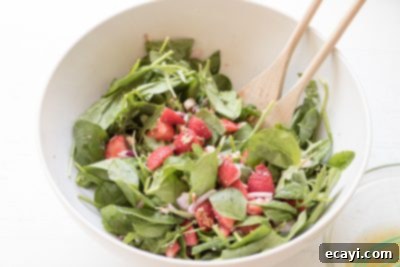 Vibrant Strawberry Salad 14 Step-by-step image showing how to combine ingredients for the Strawberry Salad in a bowl.