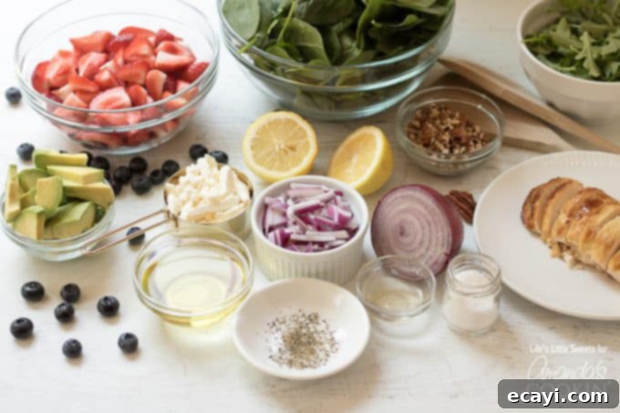 Vibrant Strawberry Salad 7 Various ingredients for the Strawberry Salad, including berries, greens, nuts, and cheese, neatly arranged in separate bowls.