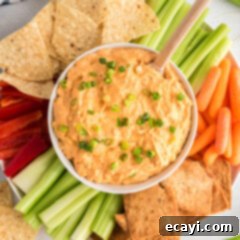 Ultimate Buffalo Chicken Dip 10 A bowl of hot Buffalo Chicken Dip, topped with blue cheese crumbles and green onions, perfect for a party.