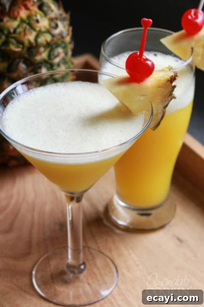 The Rum Cruiser Cocktail is a delicious blend of coconut rum, amber rum, banana liqueur, pineapple juice and orange juice. It's similar to a Rum Runner, but without the blackberry liqueur and grenadine. #comebacknew #cruisecocktail #alaskancruise #princesscruises #mixeddrinks #drinkswithrum #sponsored Rum cocktail in a martini glass, garnished with a cherry and pineapple wedge
