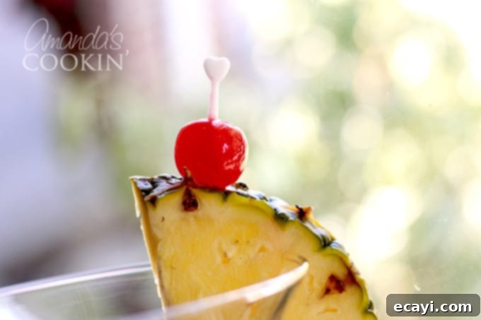 Rum Cruiser 4 pineapple wedge and maraschino cherry garnish on a glass rim