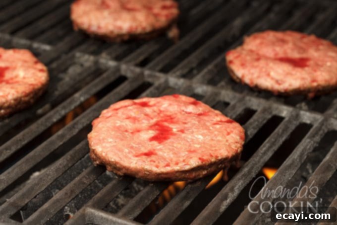 Master Your Backyard Barbecue 5 Hamburgers cooking on the grill, showing browning and juices forming