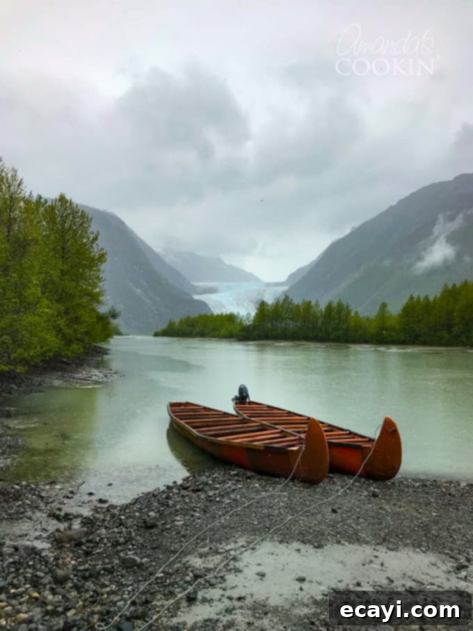 Discover the Davidson Glacier Canoe Tour in Skagway, Alaska – an ultimate Alaskan cruise excursion through forests and to a magnificent glacier! #alaskancruise #alaskaexcursion #canoetour #glaciertour #skagwayalaska #visitalaska #travelalaska #sponsored #princesscruises @princesscruises #comebacknew canoes on shore with Davidson Glacier in the background