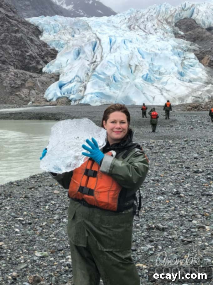 For the best Alaska excursion ideas, choose the Davidson Glacier Canoe Tour – a journey through beautiful Alaska forests and out to a magnificent glacier! #alaskancruise #alaskaexcursion #canoetour #glaciertour #skagwayalaska #visitalaska #travelalaska #sponsored #princesscruises @princesscruises #comebacknew A person standing in front of a Davidson Glacier holding a big chunk of ice