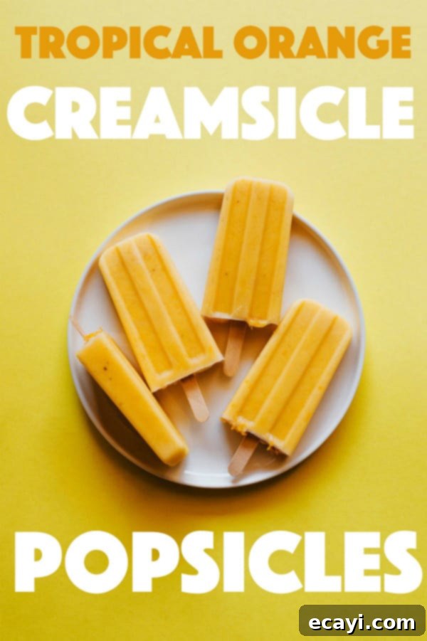 Learn how to make delicious homemade creamsicle popsicles at home! A much healthier option that the creamsicles you buy at the store! With ingredients like orange juice, chopped mango, banana and Greek yogurt, how can you go wrong? #healthydessert #popsicles #homemadepopsicles #healthy #forkids #easy #fruit #popsiclesforkids #homemadepopsiclesforkids #easyhomemadepopsicles #fruitpopsicles #popsiclerecipes #mango #banana #greekyogurt #yogurt #orange #orangejuice #creamsicle Tropical Orange Creamsicle Popsicles