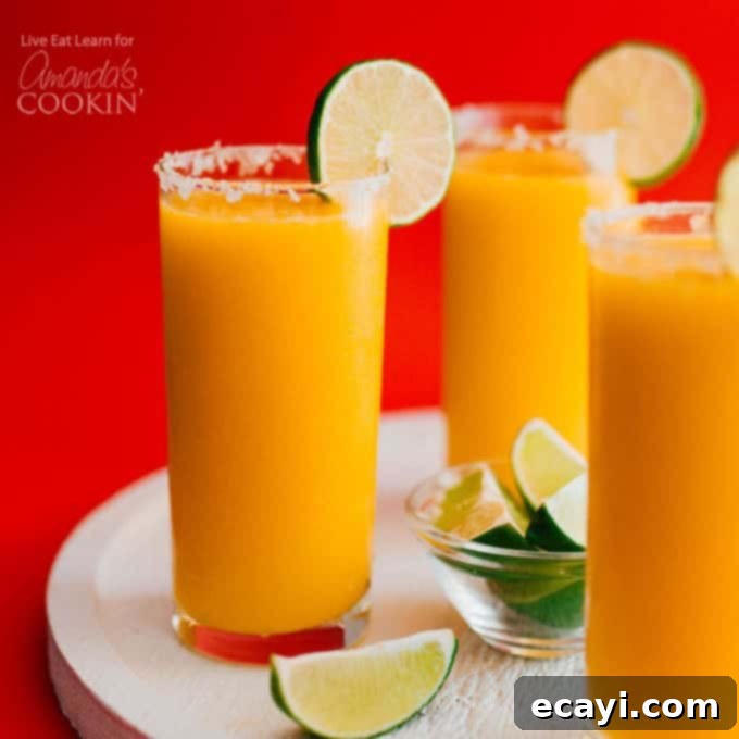 Serve your homemade Mango Margarita Slush with a festive garnish 3 glasses of mango margarita slush with lime garnish