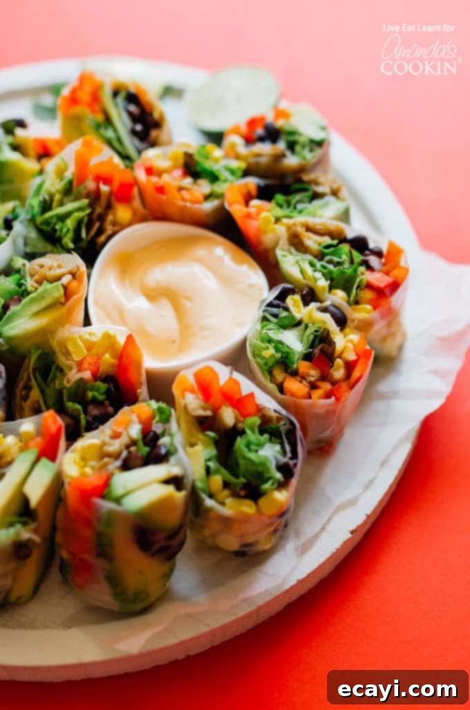 These Mexican Style Summer Rolls are a fresh and delicious recipe to cook up for your summer meal prepping, snacking or dinner. Mexican Style Summer Rolls on a plate with dipping sauce