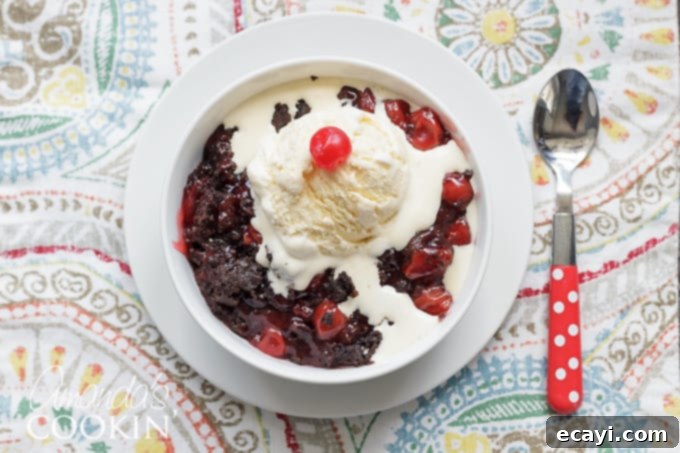 Decadent Slow Cooker Chocolate Cherry Cobbler 3 A generous serving of crockpot chocolate cherry cobbler in a bowl, showing its rich, dark color and juicy cherry filling.