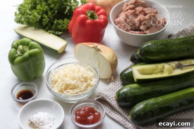 These colorful stuffed zucchini boats are a savory and delicious dinner packed with lean protein and a healthy serving of vegetables. Stuffing zucchini with lean ground turkey, fresh peppers, onions, and grated cheese makes for a tasty low-carb dinner and is a great way to use up all that garden zucchini! #zucchiniboats #stuffedzucchini #zucchinirecipes #lowcarbdinners #lowcarbrecipes #groundturkey #zucchini #amandascookin Ingredients laid out for making stuffed zucchini boats