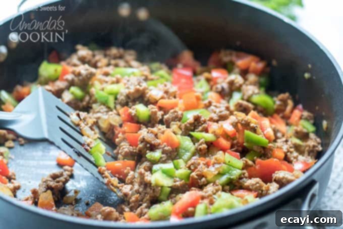 Zucchini Pockets 3 Skillet with ground turkey, bell peppers, and onions cooking