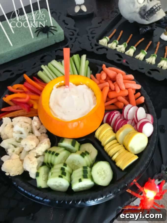If you need Halloween food ideas for your Halloween party, be sure to check out all these sweet, savory and beverage ideas! Something for everyone. #halloweenrecipes #halloweenfoodideas #halloweenfood #halloweentreats #halloweenpartyfood #mummycookies #mozarellaeyeballs #spidertacodip #spidercookies #ricekrispypumpkins #ricekrispymonsters #dipinapumpkin #halloweenparty veggies with dip in a pumpkin