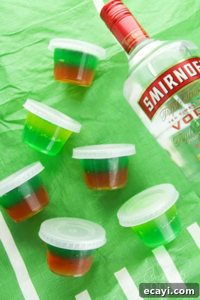 Love tailgating? Portable football jello shots are perfect for it! Watch the game at home or the stadium, these football jello shots are great! #jelloshots #footballjelloshots #footballteamjelloshots #footballfood #tailgating #tailgatingcocktails #sponsored #IbottaPartner #howtomakejelloshots #amandascookin Vibrant football jello shots in team colors, ready for tailgating