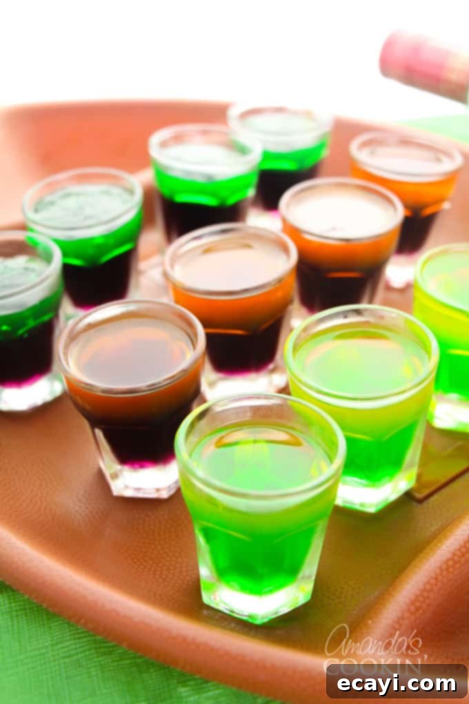 Love tailgating? Portable football jello shots are perfect for it! Watch the game at home or the stadium, these football jello shots are great! #jelloshots #footballjelloshots #footballteamjelloshots #footballfood #tailgating #tailgatingcocktails #sponsored #IbottaPartner #howtomakejelloshots #amandascookin A colorful plate of football jello shots arranged for a tailgating party