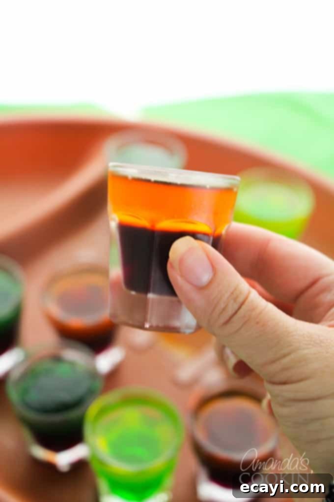 Love tailgating? Portable football jello shots are perfect for it! Watch the game at home or the stadium, these football jello shots are great! #jelloshots #footballjelloshots #footballteamjelloshots #footballfood #tailgating #tailgatingcocktails #sponsored #IbottaPartner #howtomakejelloshots #amandascookin Assortment of football team-colored jello shots in a stylish display