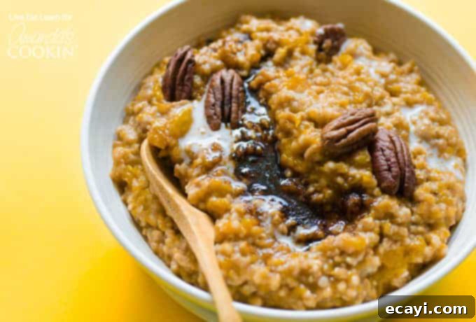 A warm and hearty breakfast for fall, crockpot butternut squash oatmeal! A close-up of creamy butternut squash oatmeal in a white bowl, garnished with whole pecans