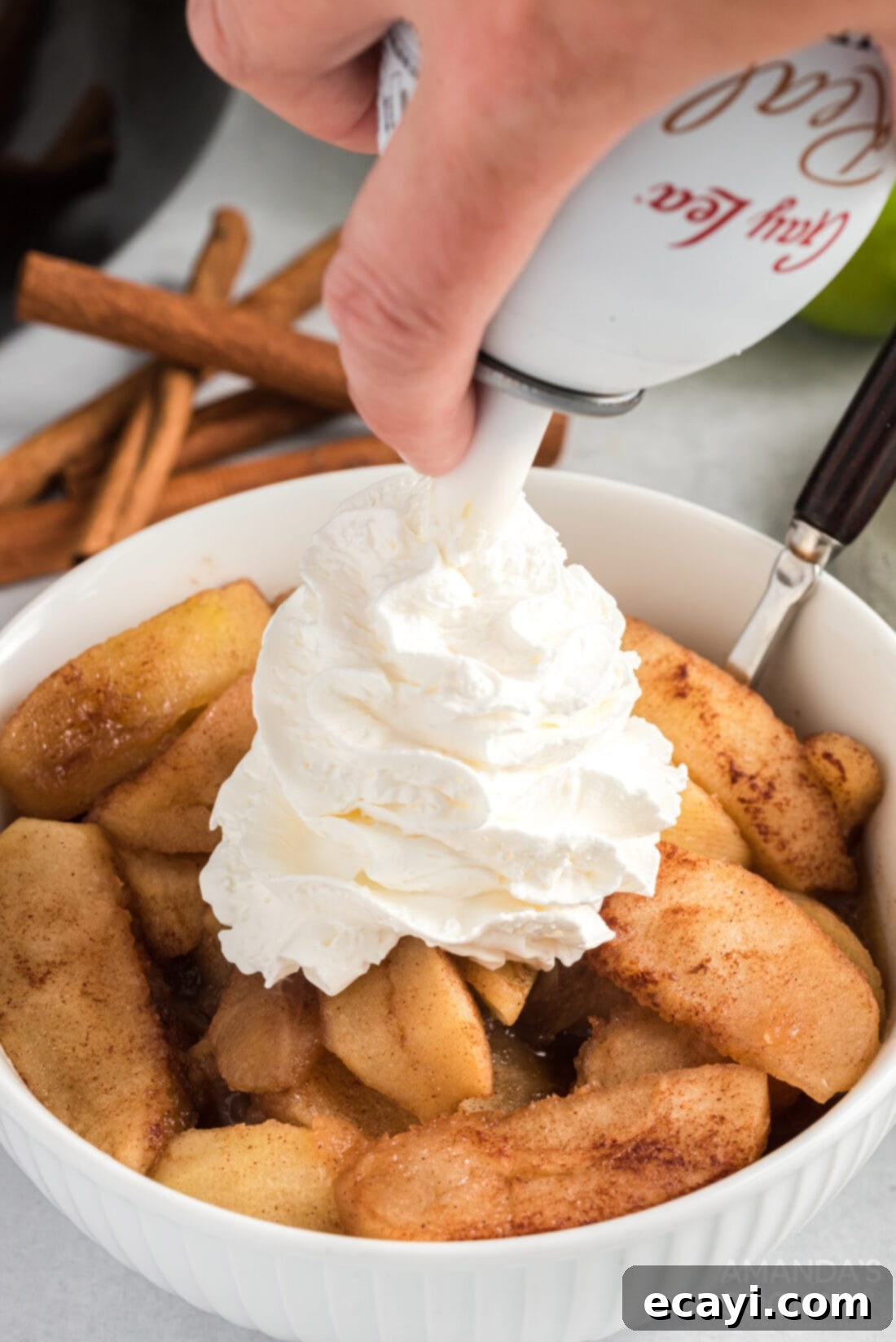 Cozy Slow Cooker Cinnamon Apples 8 adding whipped cream to Crockpot Cinnamon Apples