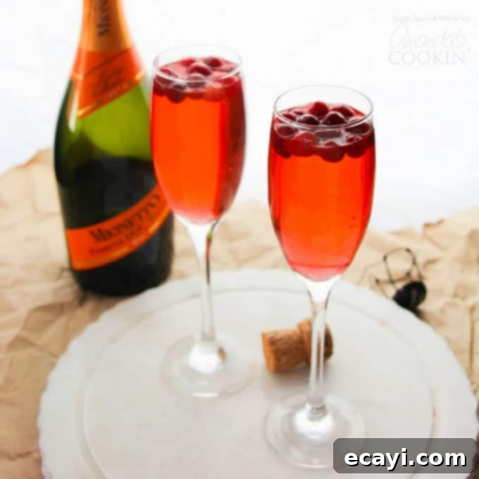 The Festive Reset Drink 3 Two elegant glasses of Cranberry Prosecco Punch, a festive cocktail for holiday gatherings.
