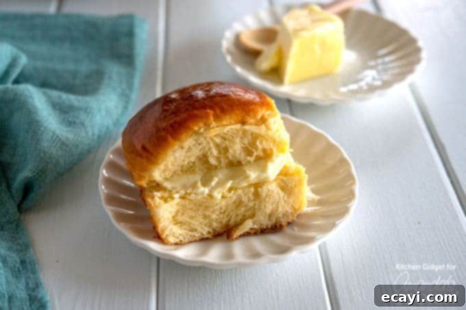 Soft Homemade Hawaiian Rolls for the Whole Family Homemade Hawaiian rolls on a white plate with butter and a knife