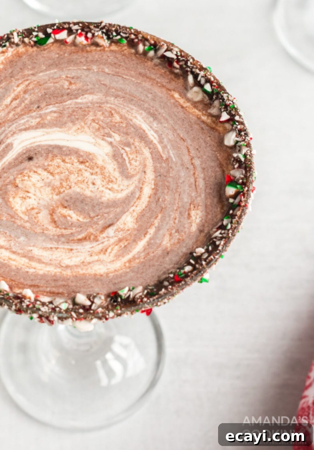 This chocolate peppermint martini is the perfect Christmas cocktail! Make for your holiday gatherings or for a tasty cocktail with Christmas dinner. #peppermint #martini #cocktails #chocolate #chocolatemartini #peppermintmartini #holidaycocktail #christmas #christmasparty #vodka #partydrinks Overhead view of a luscious Chocolate Peppermint Martini, garnished with a chocolate and crushed candy cane rim.