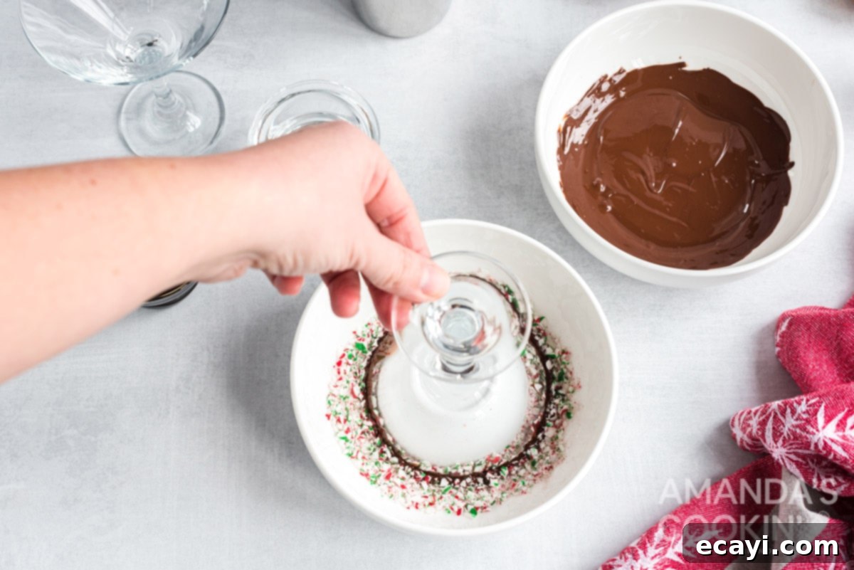 Applying crushed peppermint to the chocolate rim of a martini glass for the signature holiday look. Dipping a chocolate-rimmed martini glass into crushed candy canes for a festive finish.