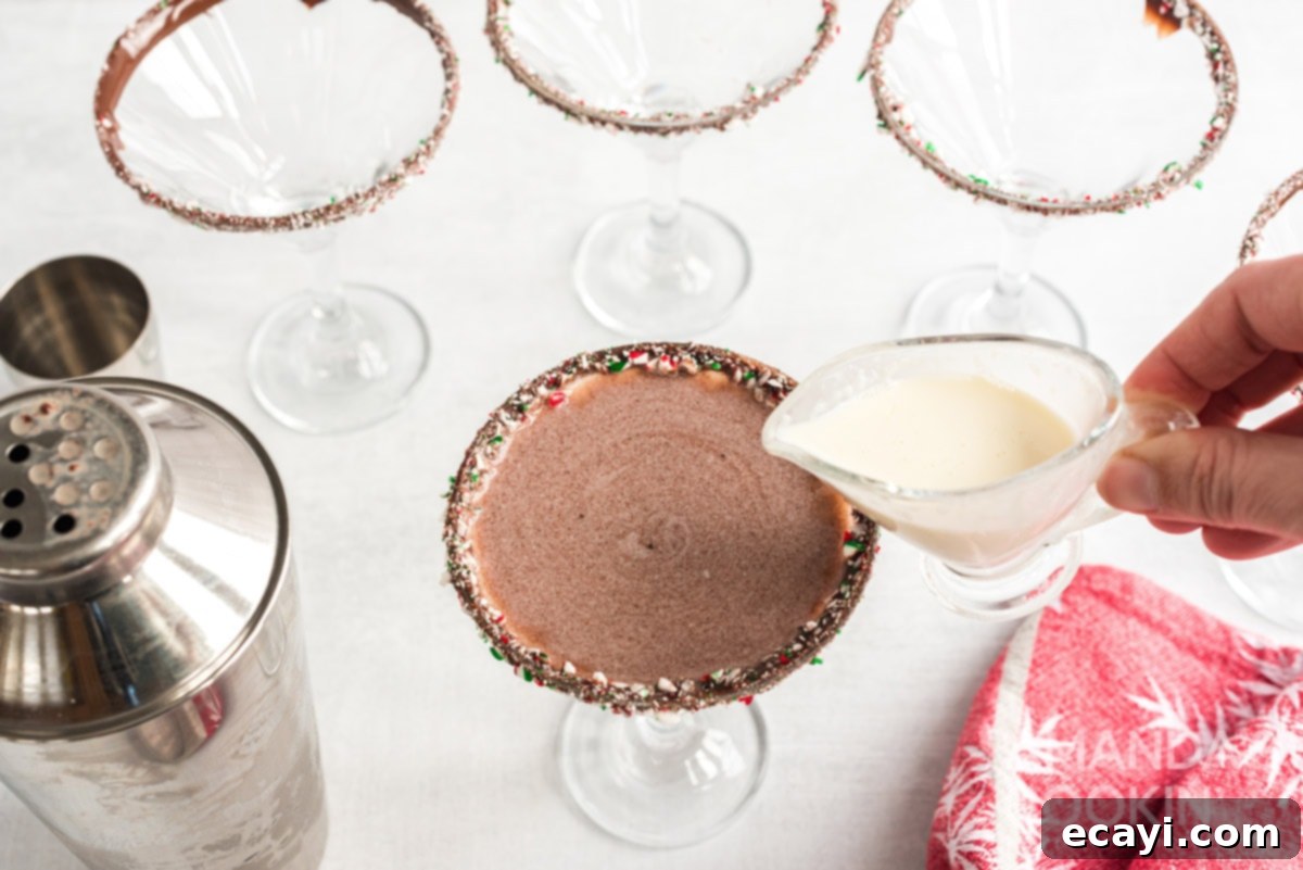 The final step: delicately adding cream to the Chocolate Peppermint Martini for a beautiful visual garnish. Adding a final touch of cream to the top of the Chocolate Peppermint Martini for a decorative swirl.
