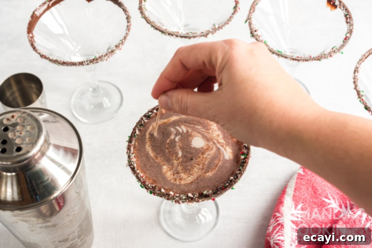 Creating a beautiful, intricate design on top of the Chocolate Peppermint Martini with a toothpick. Using a toothpick to create an elegant swirl design in the cream garnish of a martini.