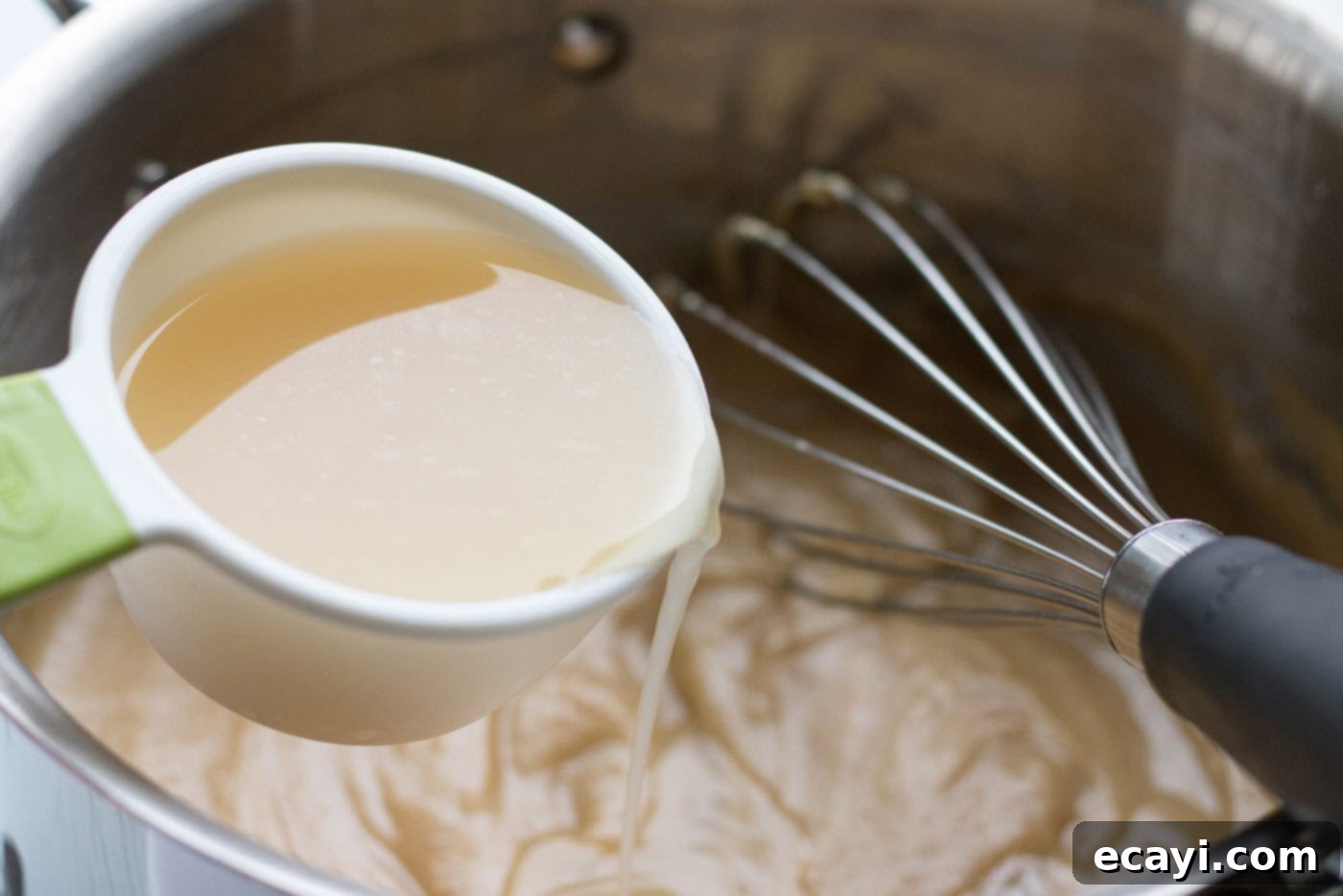 Perfect Turkey Gravy From Scratch 12 Broth being added into a saucepan
